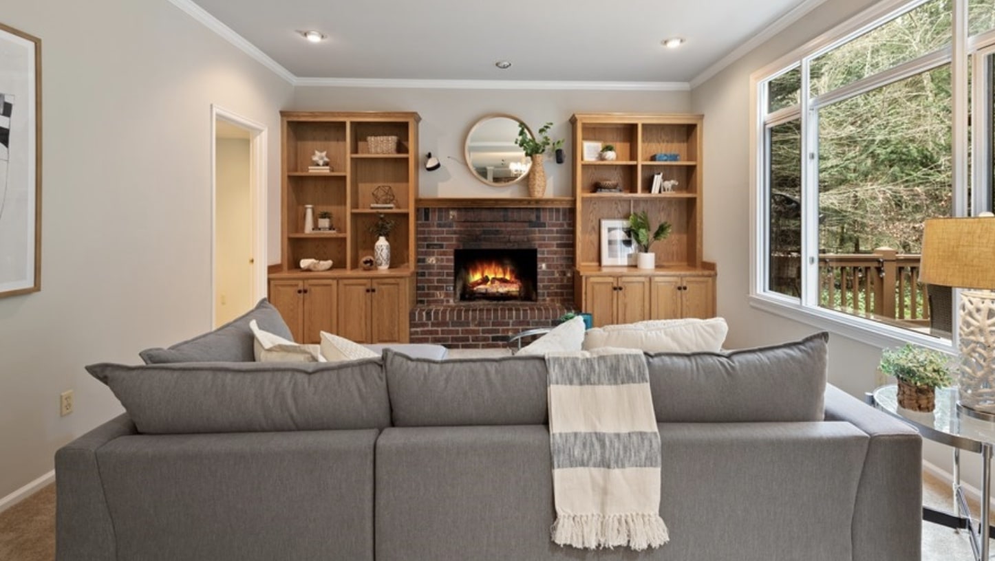 Modern great room with custom shelving surrounding the brick fireplace