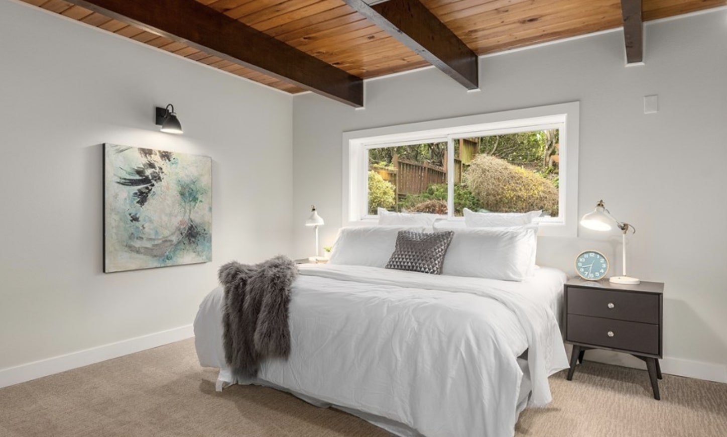 Modern guest suite with shiplap ceiling and wood beams