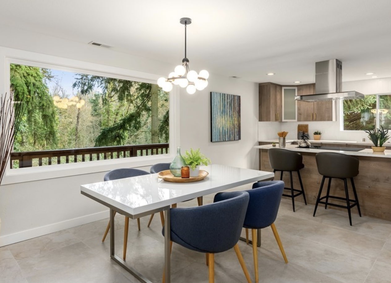 Modern furniture and art enhance the remodeled dining and kitchen space with treetop views