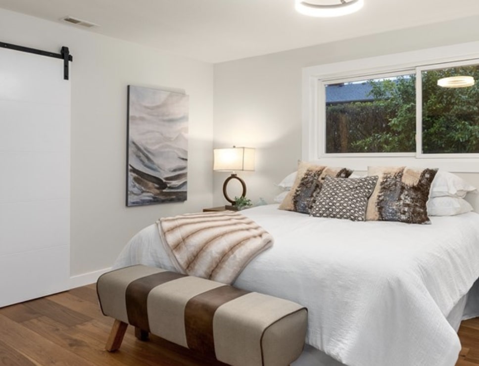 The primary bedroom features original wood floors complimented by a casual color palette
