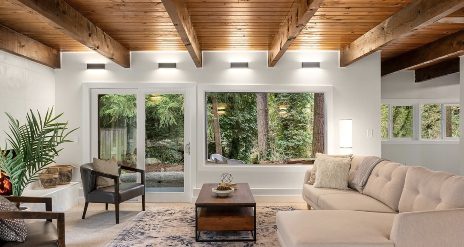 Spacious casual family room featuring wood beams and shiplap ceiling